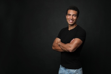 Photo of Handsome young African-American man on black background