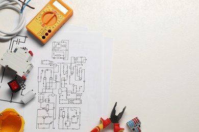 Photo of Flat lay composition with wiring diagrams and digital multimeter on white table, space for text