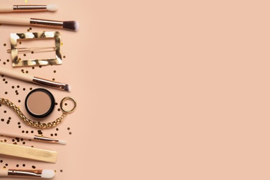 Photo of Flat lay composition with makeup brushes on beige background. Space for text