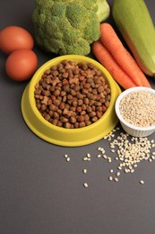 Photo of Dry pet food and products on black background