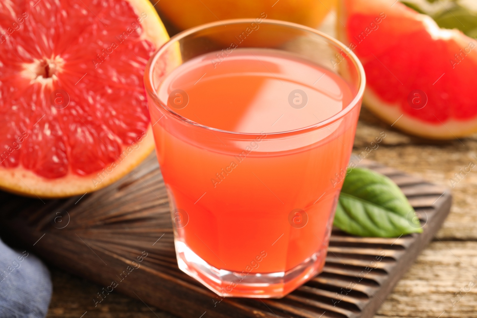 Glass of delicious grapefruit juice on wooden table, closeup Photo of Glass of delicious grapefruit juice on wooden table, closeup