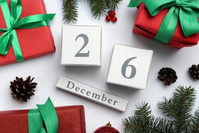 Photo of Flat lay composition with block calendar and gifts on white background. Boxing day concept
