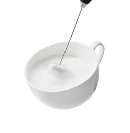 Whisking milk in cup with mini mixer (frother wand) isolated on white, closeup