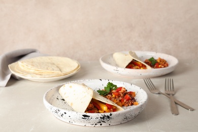 Photo of Chili con carne served with tortilla on table