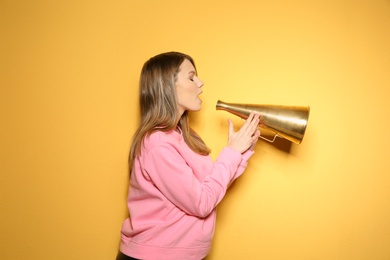 Photo of Young woman with megaphone on color background