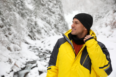 Photo of Handsome man wearing warm clothes outdoors on snowy day. Winter vacation