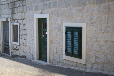 Old residential building with windows and doors in stone wall