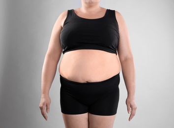 Photo of Fat woman on grey background, closeup. Weight loss