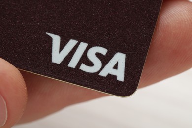 Photo of MYKOLAIV, UKRAINE - FEBRUARY 22, 2022: Woman holding Visa credit card on white background, closeup