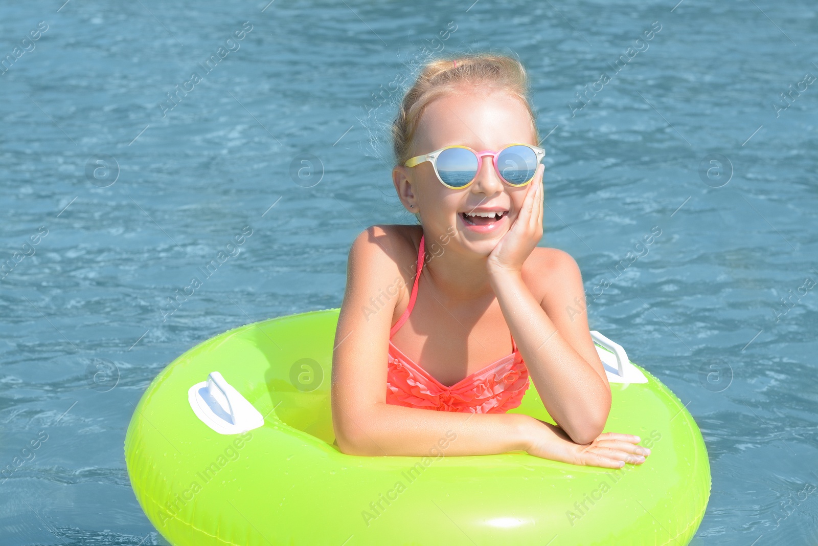 Photo of Happy little girl with inflatable ring in sea on sunny day