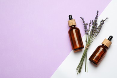 Photo of Bottles of face serum and beautiful flowers on color background, flat lay. Space for text