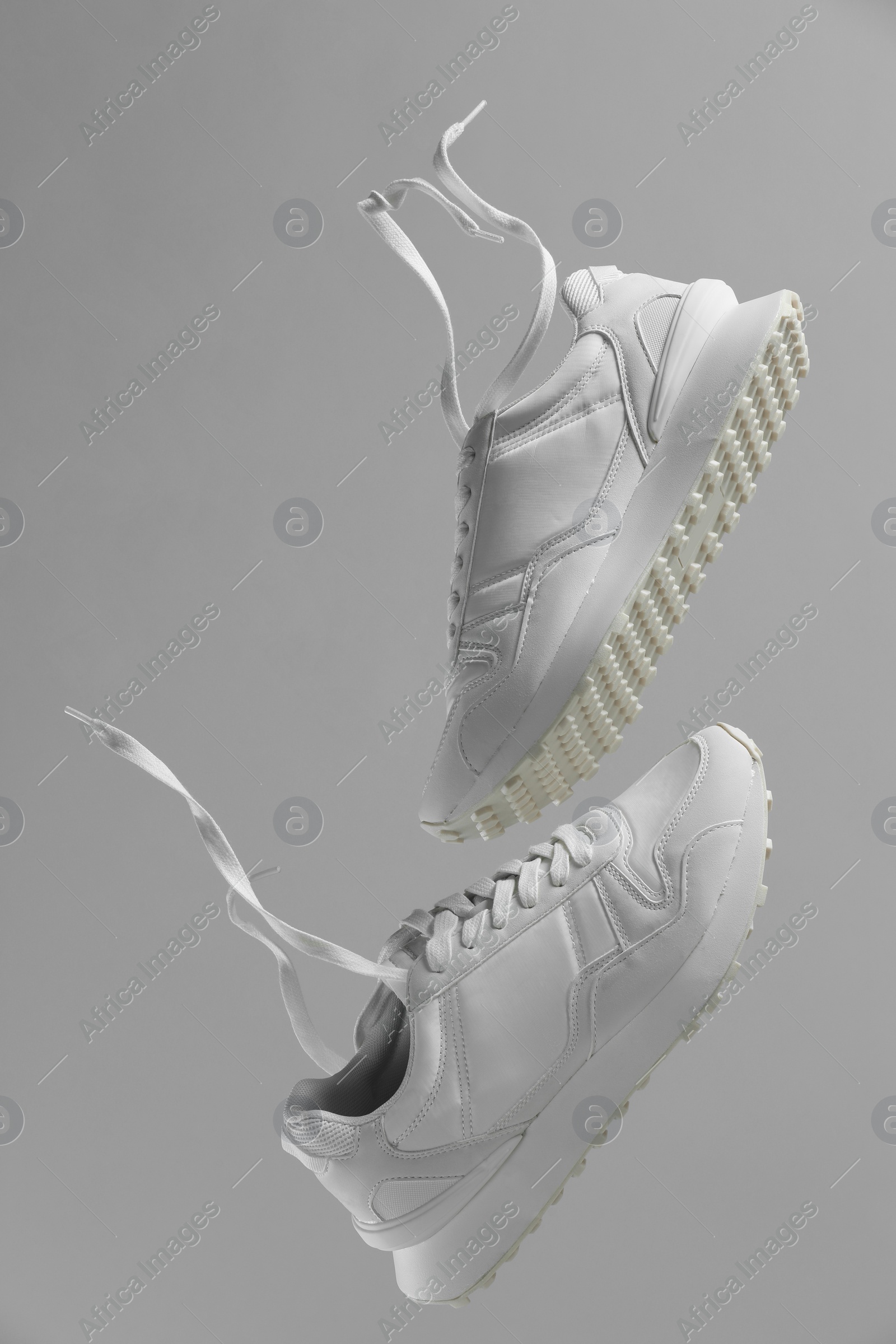 Photo of Pair of stylish white sneakers on light grey background