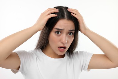 Photo of Emotional woman suffering from dandruff problem on white background