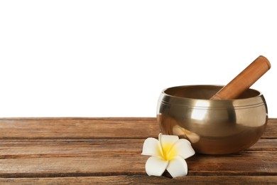 Golden singing bowl, mallet and flower on wooden table against white background, space for text