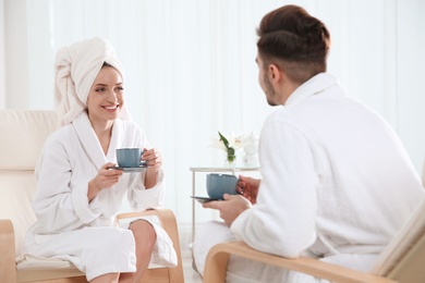 Photo of Romantic young couple with tea in spa salon