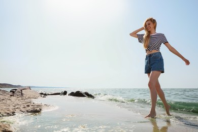 Photo of Beautiful young woman near sea on sunny day in summer