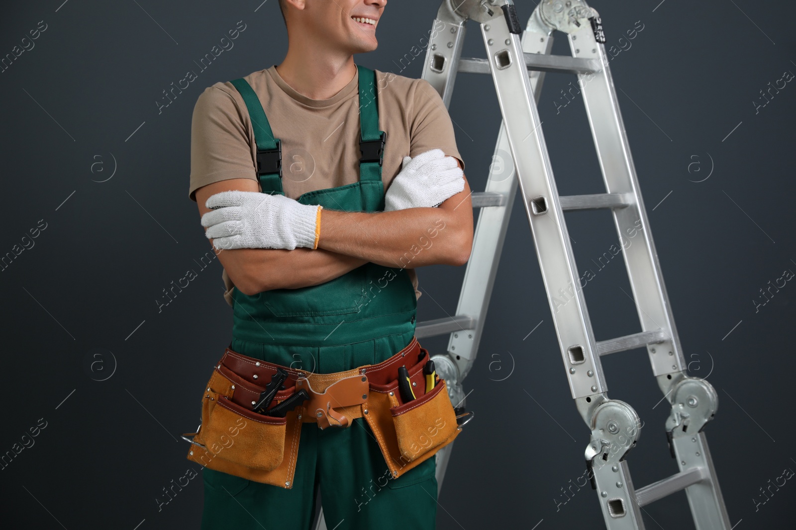 Photo of Professional constructor near ladder on black background, closeup