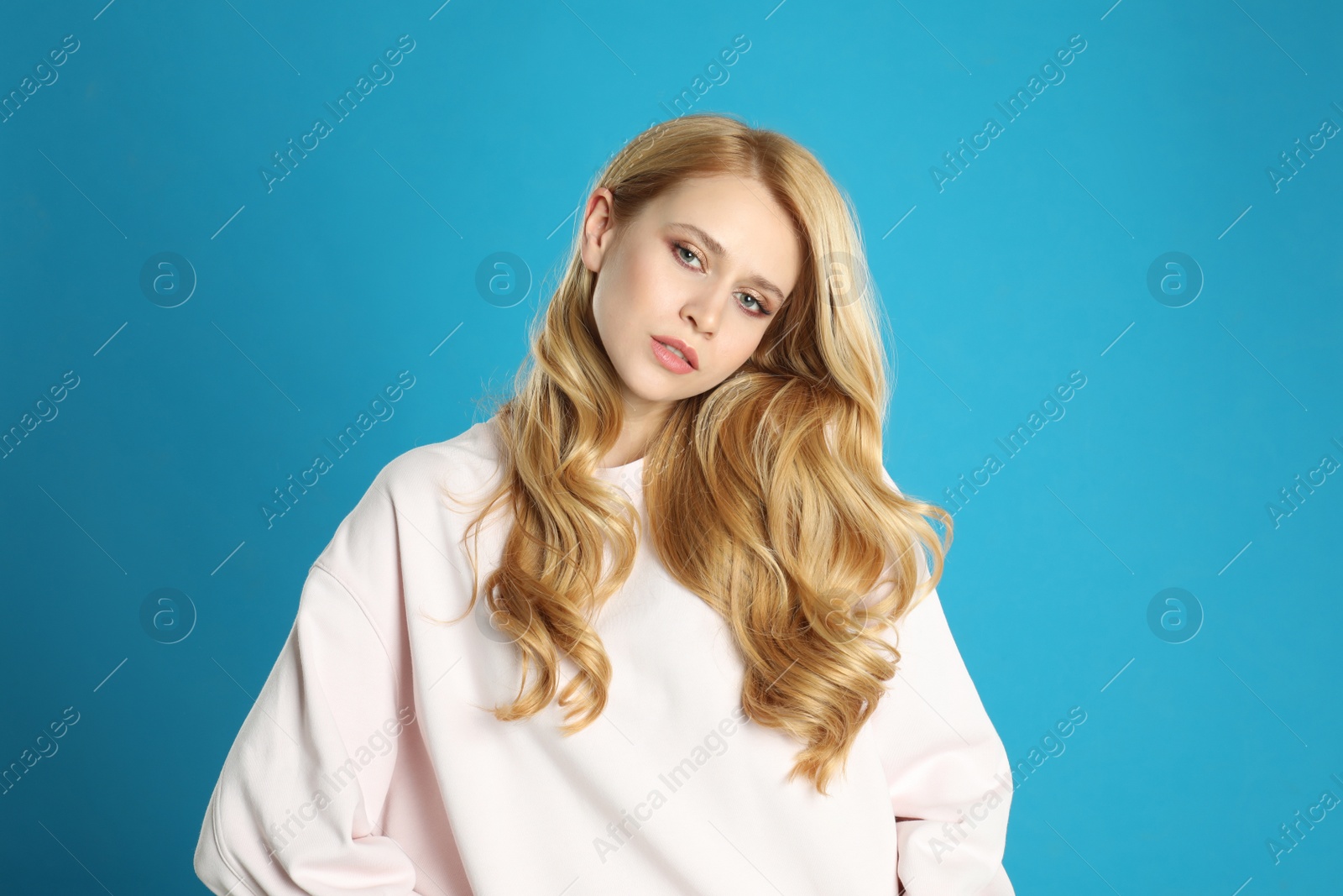 Photo of Portrait of beautiful young woman with dyed long hair on blue background