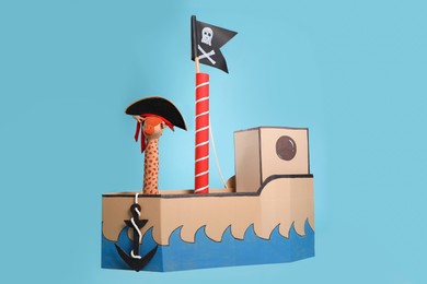 Photo of Pirate cardboard ship with flag on turquoise background