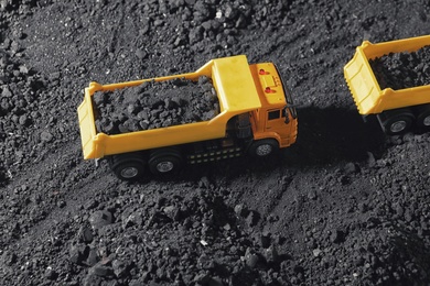 Toy tipper trucks with coal in field