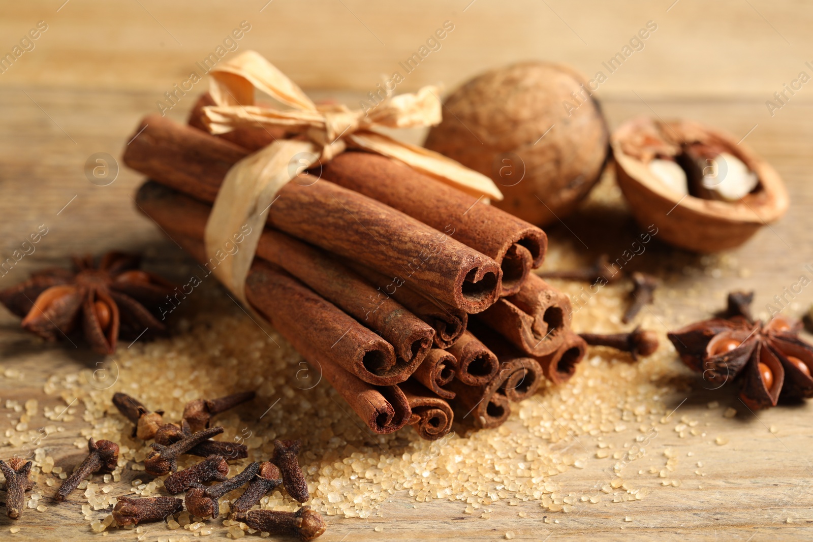 Photo of Different spices and nuts on wooden table, closeup