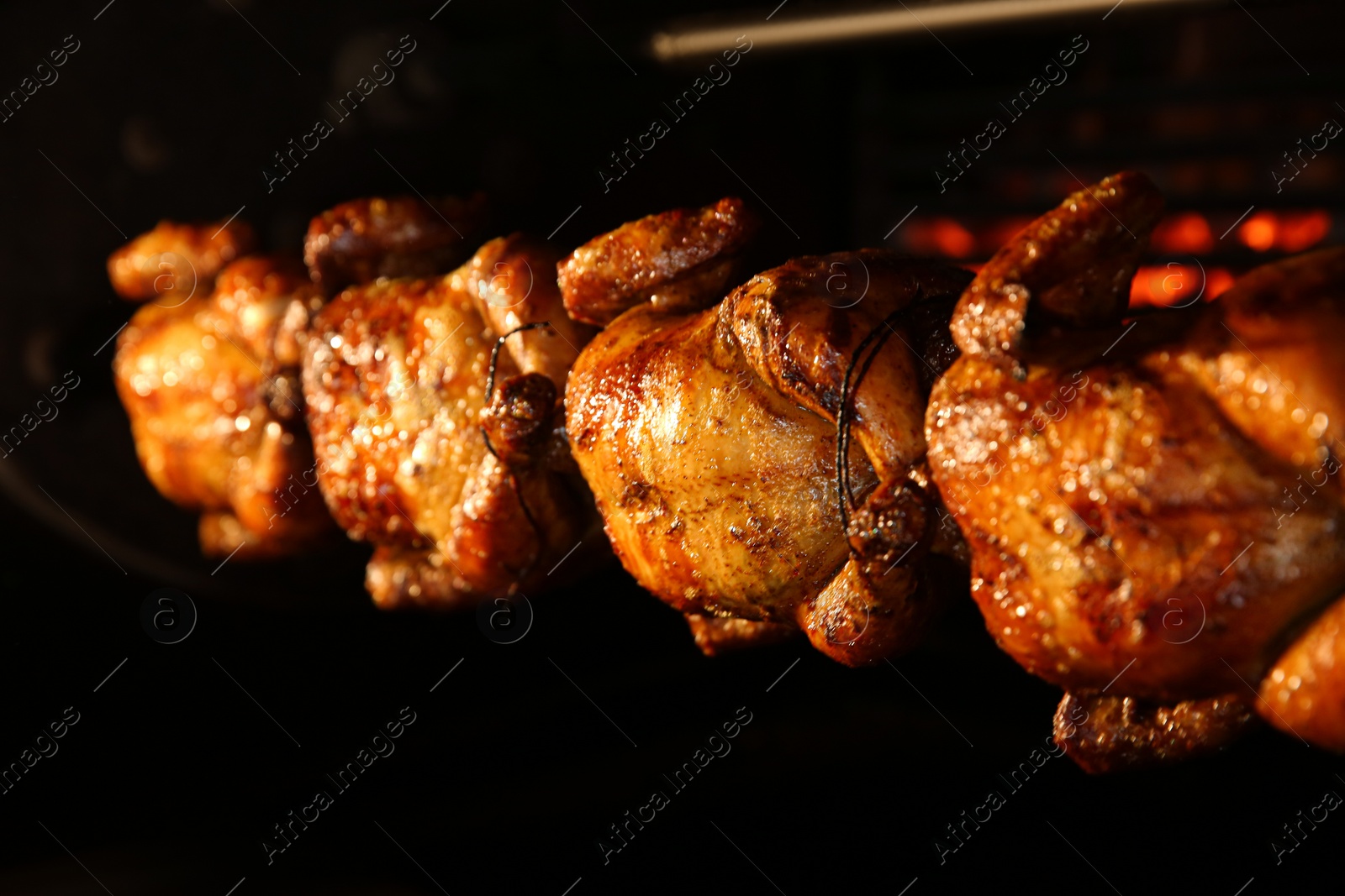 Photo of Grilling whole chickens in rotisserie machine, closeup