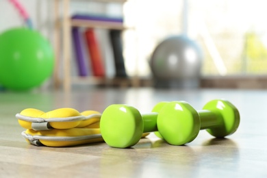 Fitness inventory on floor in spacious gym, space for text. Rehabilitation medicine