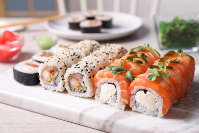 Set of different tasty sushi rolls on white table