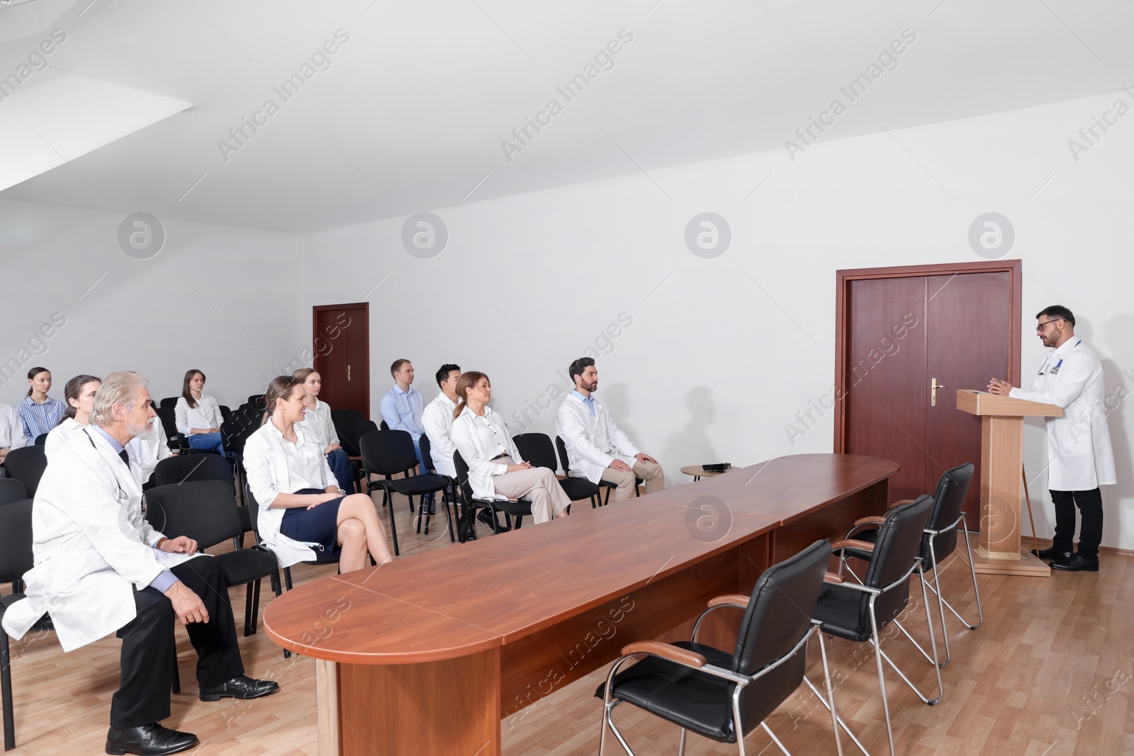 Photo of Doctor giving lecture to audience during medical conference in meeting room