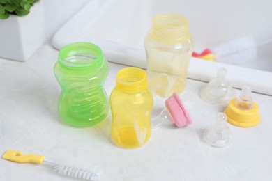 Photo of Baby bottles and nipples after washing on white countertop in kitchen, above view