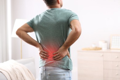 Image of Man suffering from back pain at home. Bad posture problem