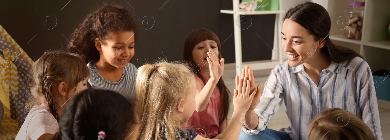 Image of Cute little children with nursery teacher in kindergarten. Banner design