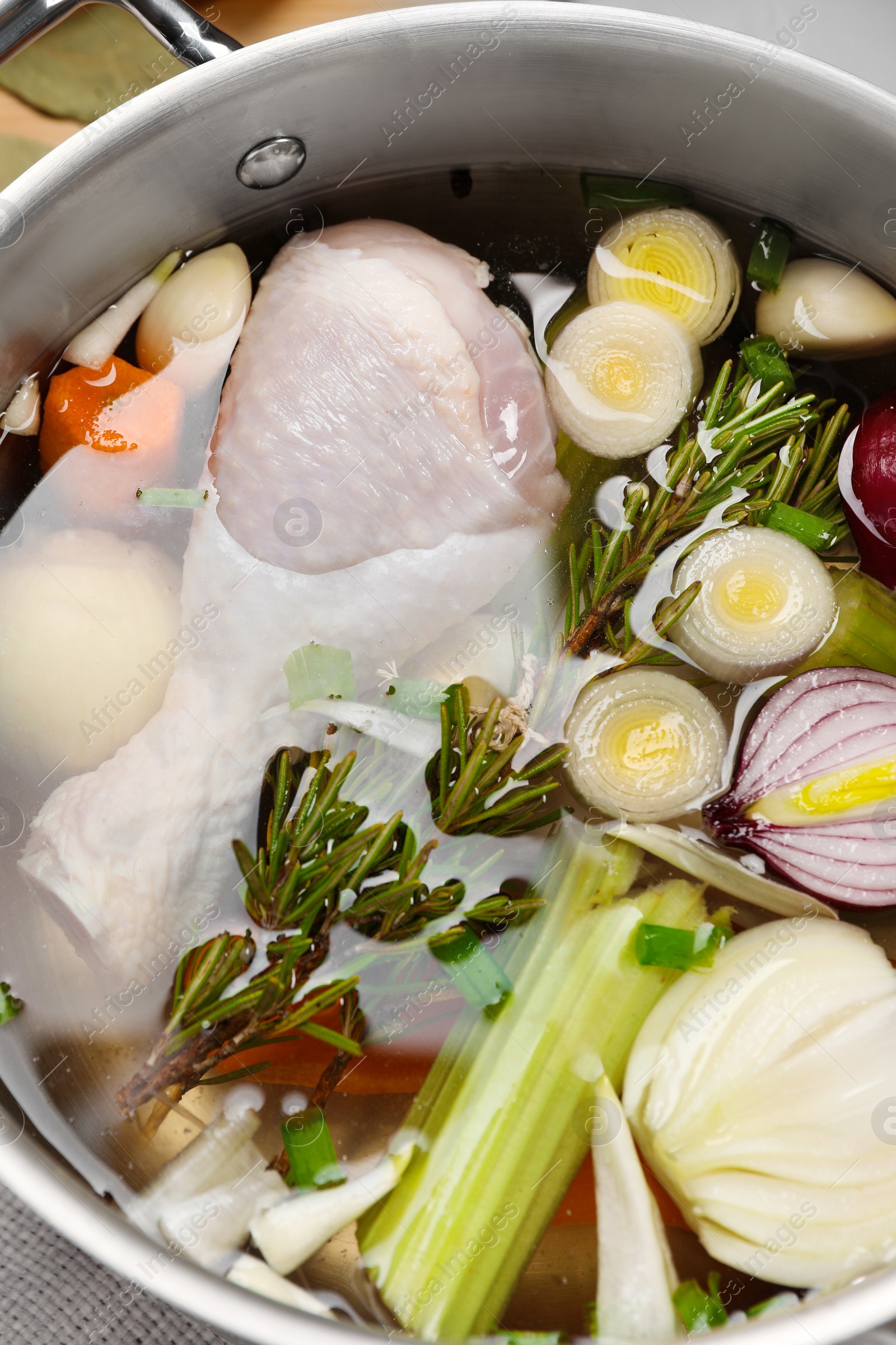 Photo of Pot with different ingredients for cooking tasty bouillon on table, top view