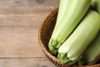 Photo of Ripe zucchinis on wooden table, closeup. Space for text