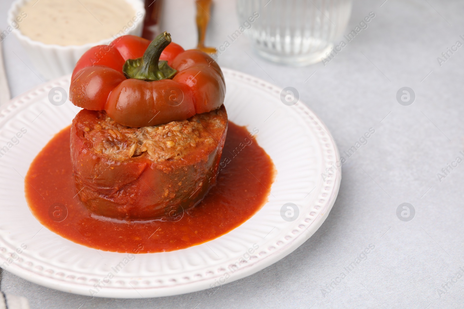 Photo of Delicious stuffed bell pepper on light table. Space for text