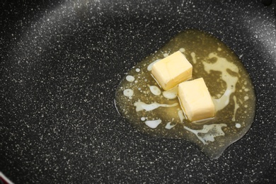 Photo of Butter melting on frying pan, closeup view