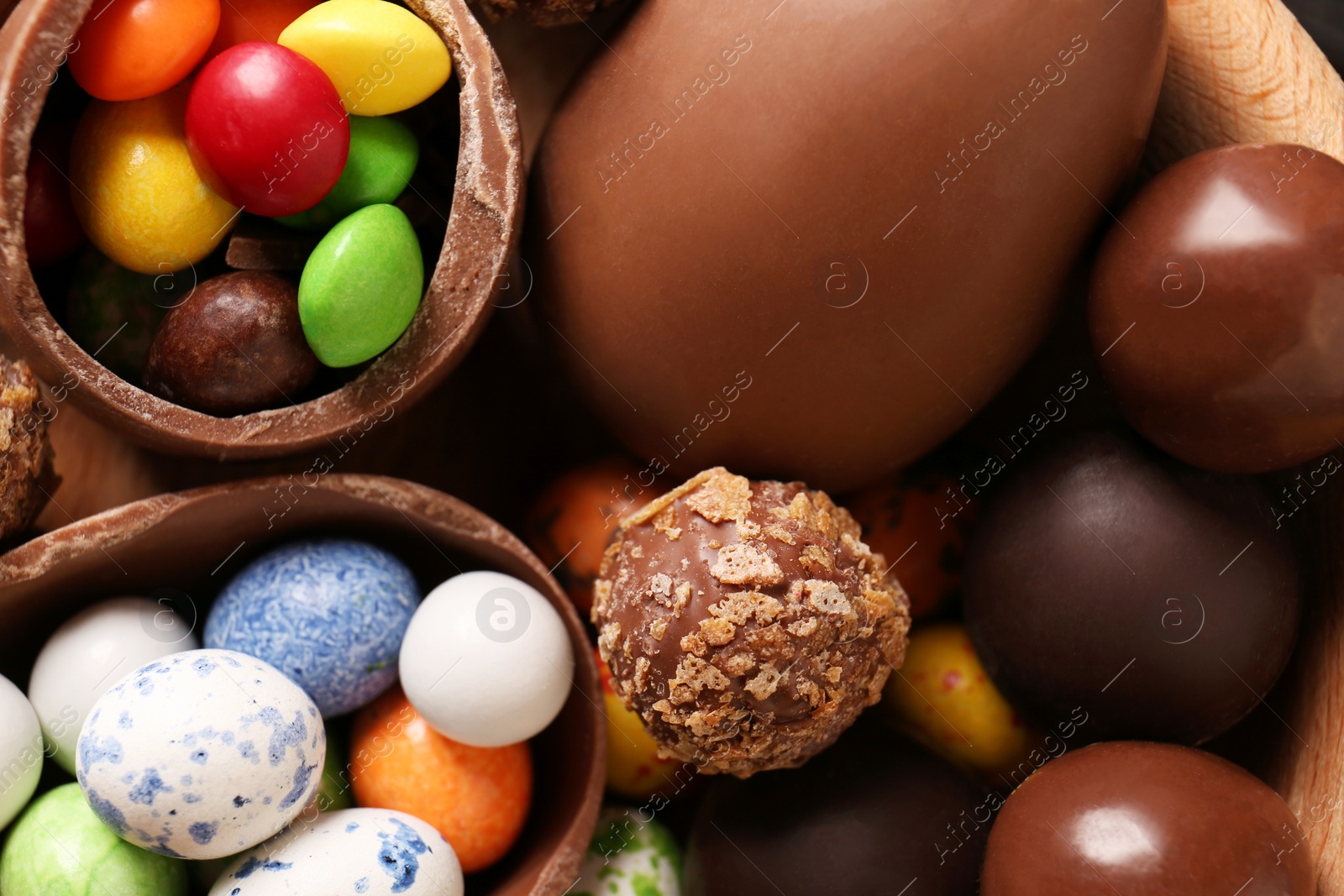 Photo of Tasty chocolate eggs and sweets as background, top view