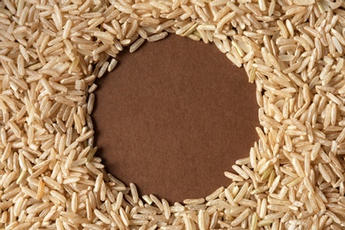 Round frame made with brown rice on color background. Space for text