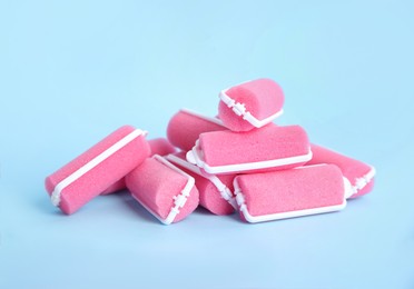 Photo of Many pink hair curlers on light blue background