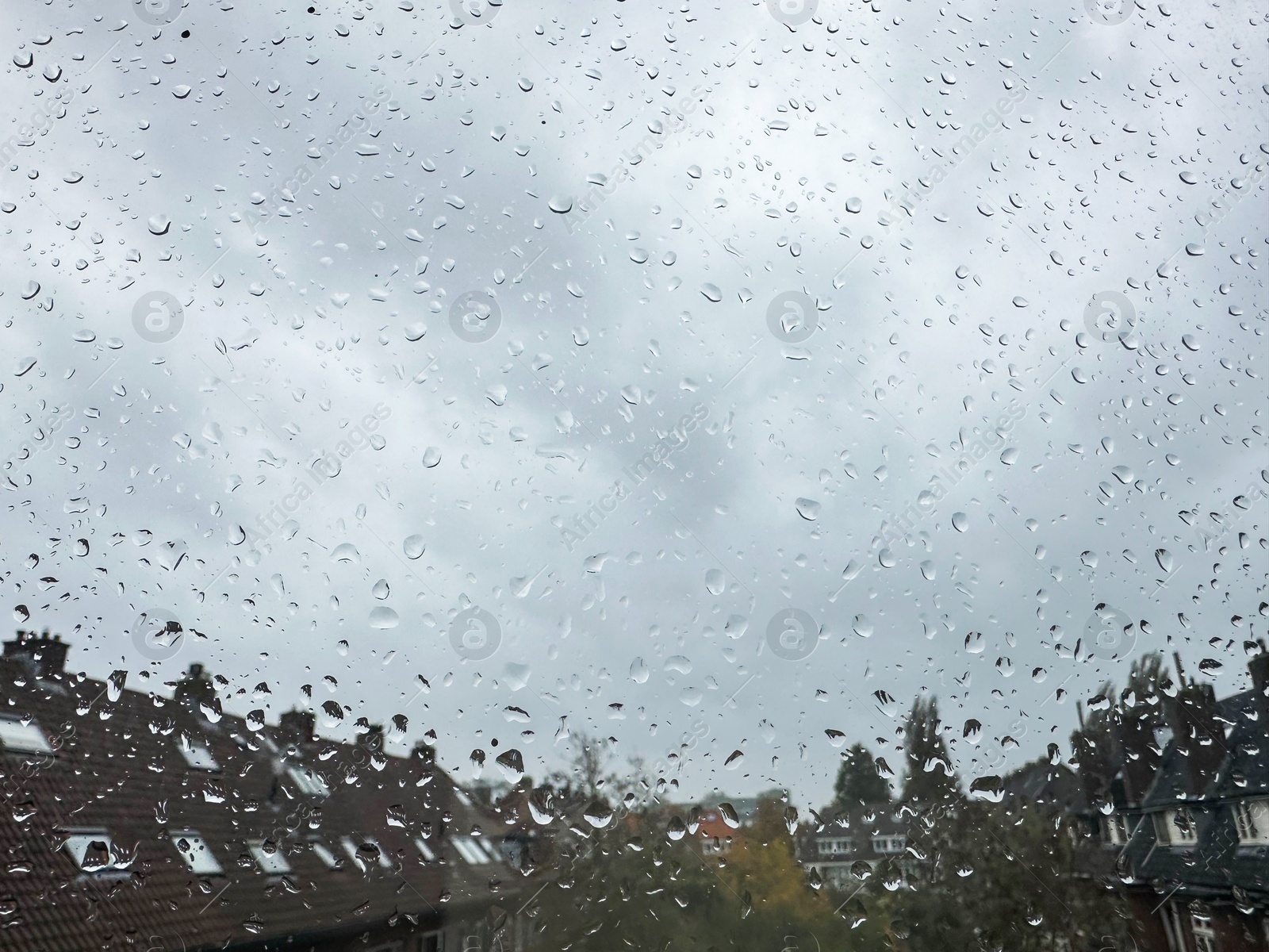 Photo of Window with water droplets on rainy day, closeup