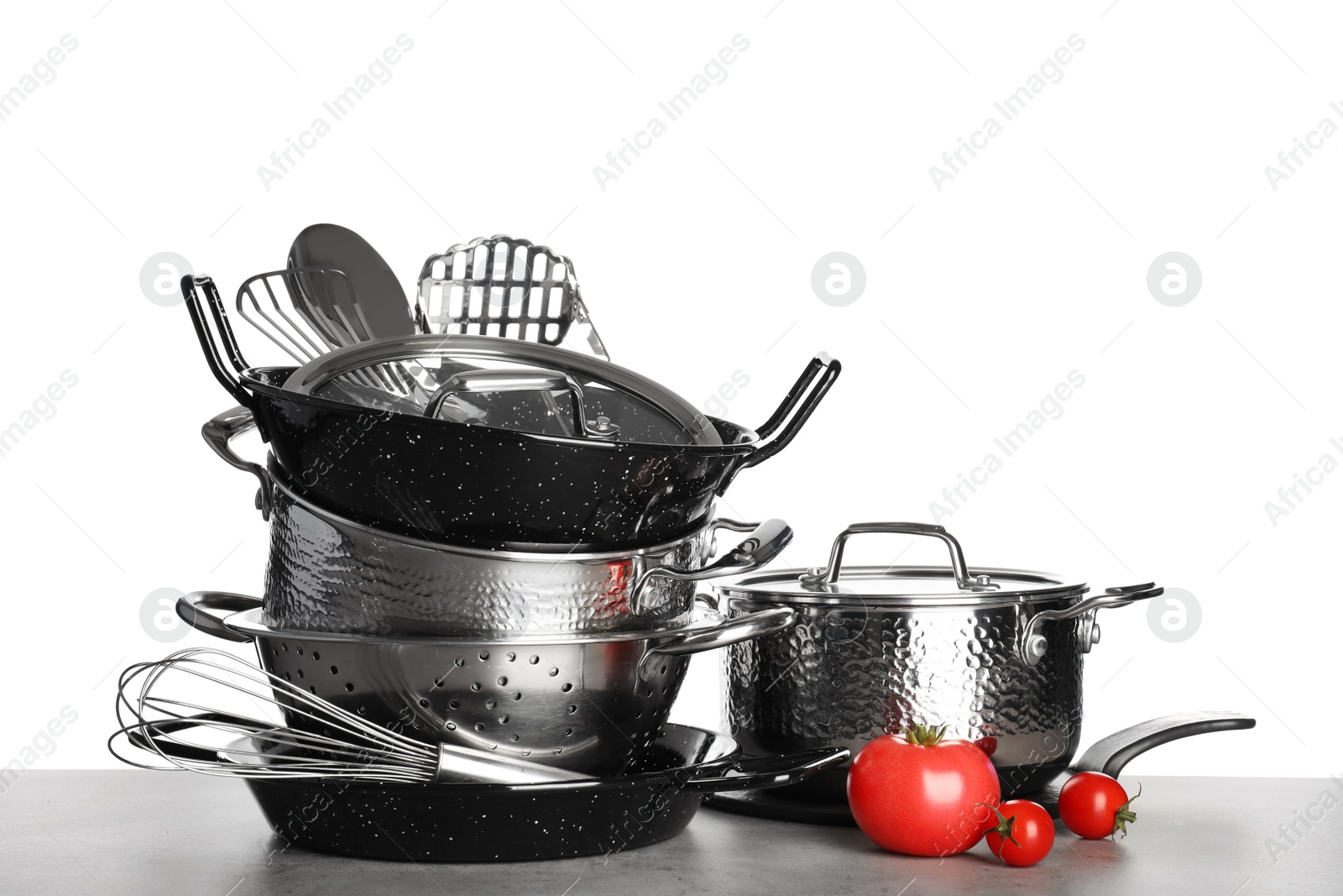 Photo of Set of clean cookware, utensils and vegetables on table against white background