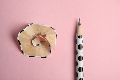 Pencil and shaving on pink background, top view