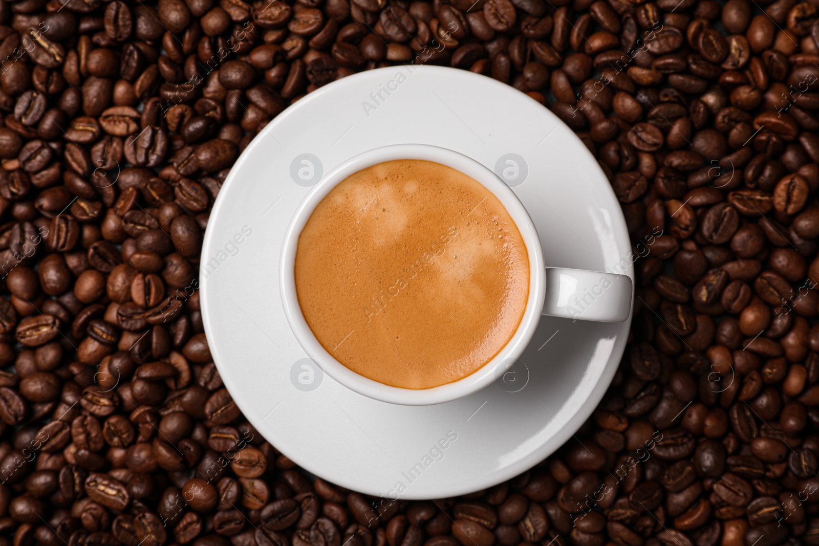 Photo of Cup of hot drink on beans, top view. Coffee Break