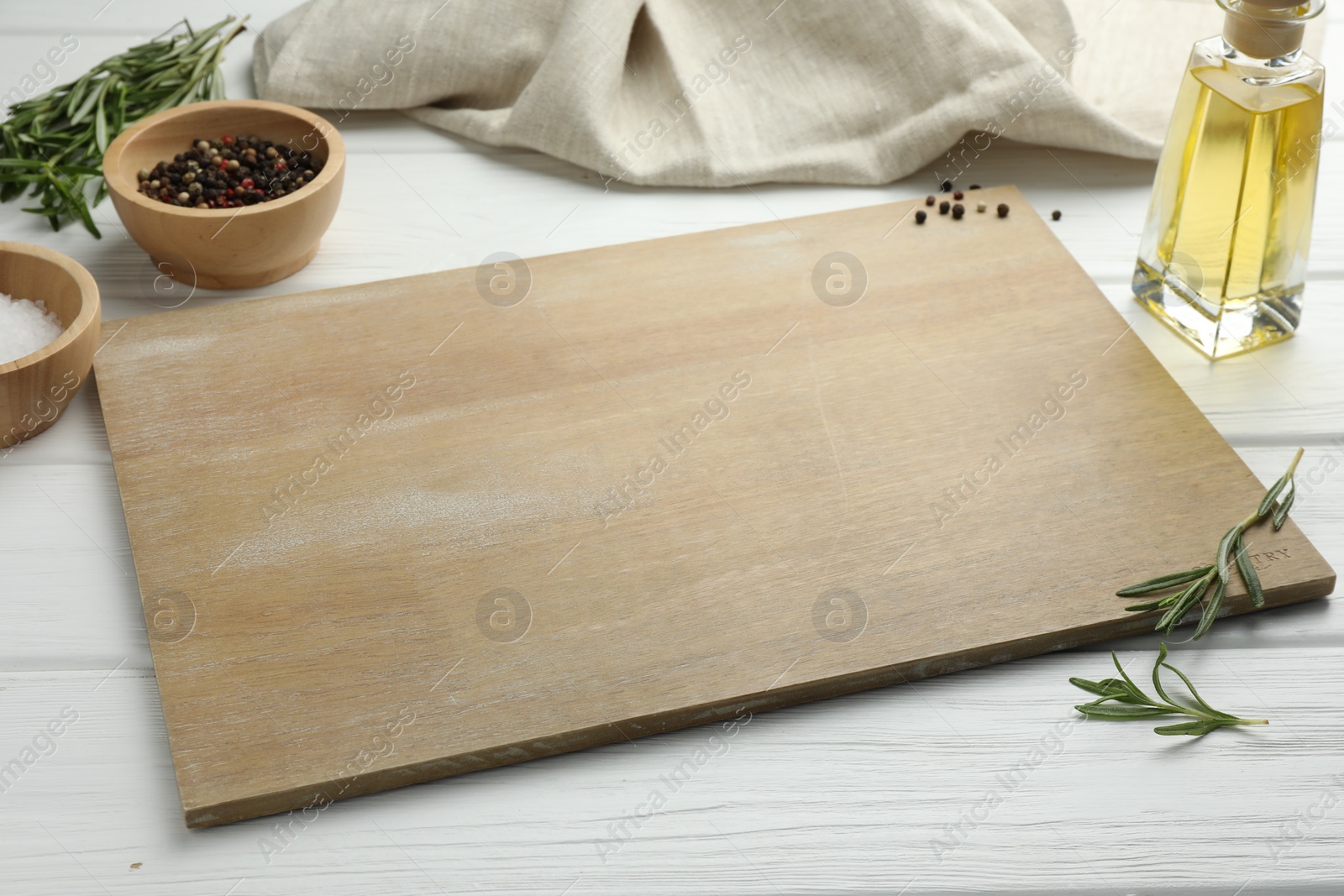 Photo of Cutting board and different spices on white wooden table