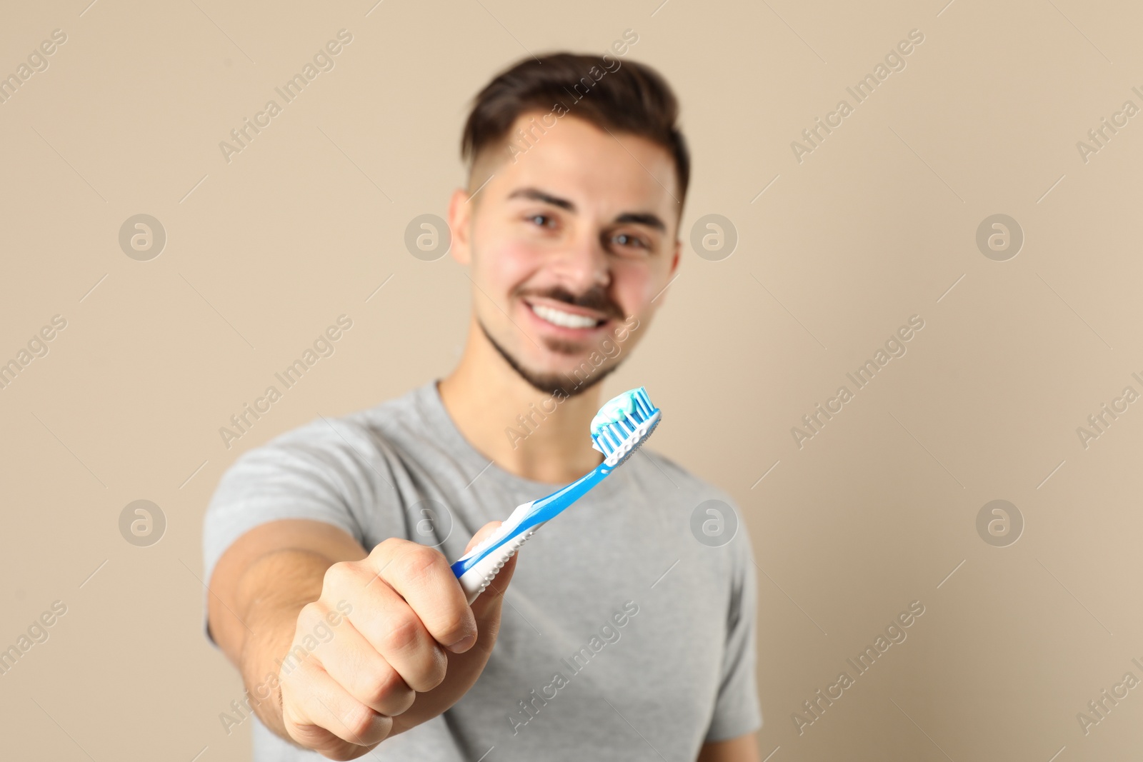 Photo of Young man with toothbrush on color background, space for text. Teeth care