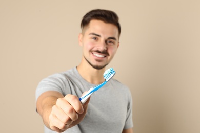 Young man with toothbrush on color background, space for text. Teeth care