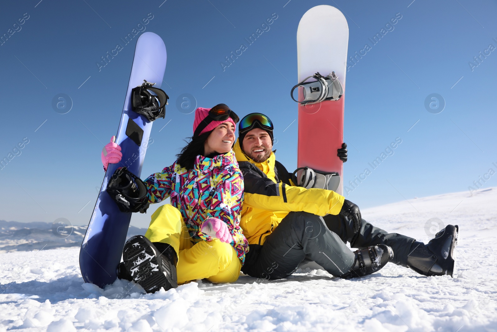 Photo of Couple with snowboards on hill. Winter vacation