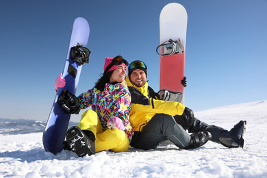 Photo of Couple with snowboards on hill. Winter vacation