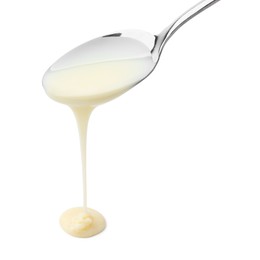 Photo of Pouring condensed milk from metal spoon isolated on white