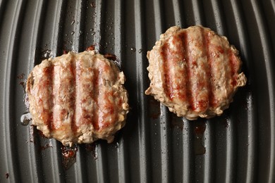 Photo of Delicious hamburger patties cooking on electric grill, top view